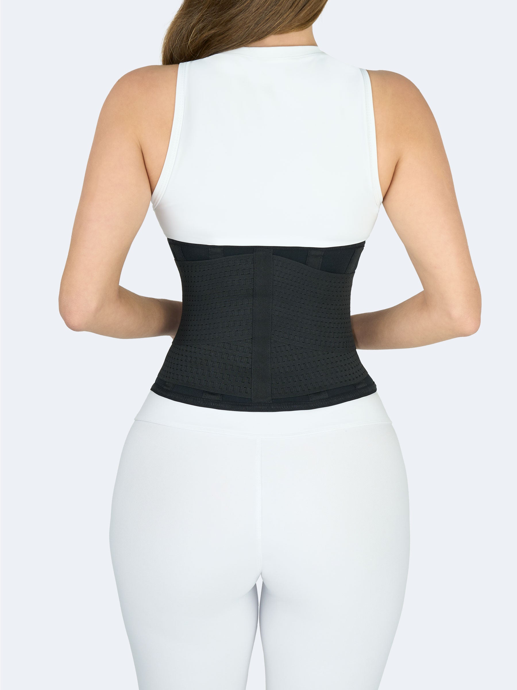 Vista posterior de mujer usando cinturon en neopreno negro tipo faja deportiva, ideal para soporte lumbar, entrenamiento y moldear la cintura. #color_Black / Negro