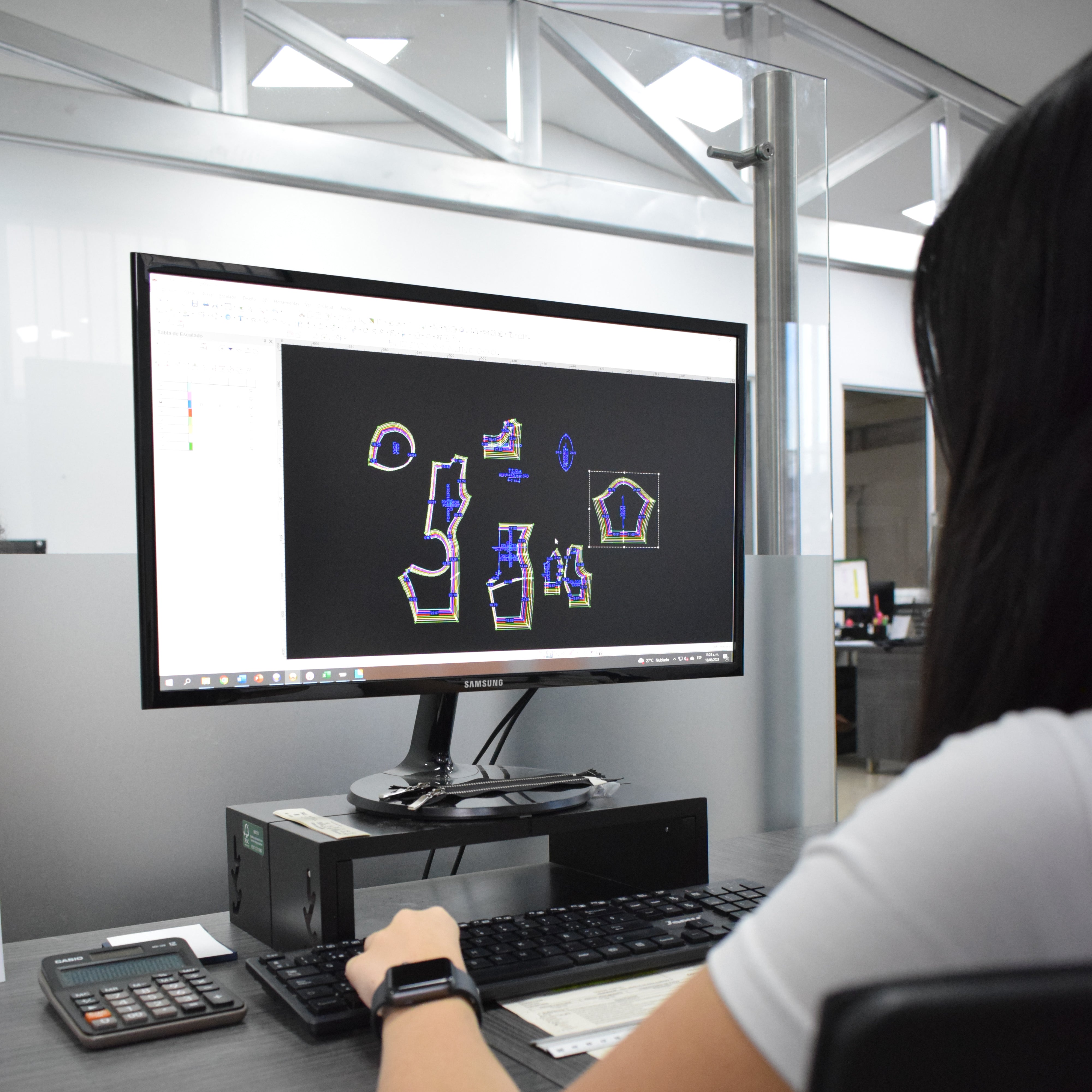 Diseñadora frente a la pantalla de un computador trabajando en el diseño de fajas colombianas