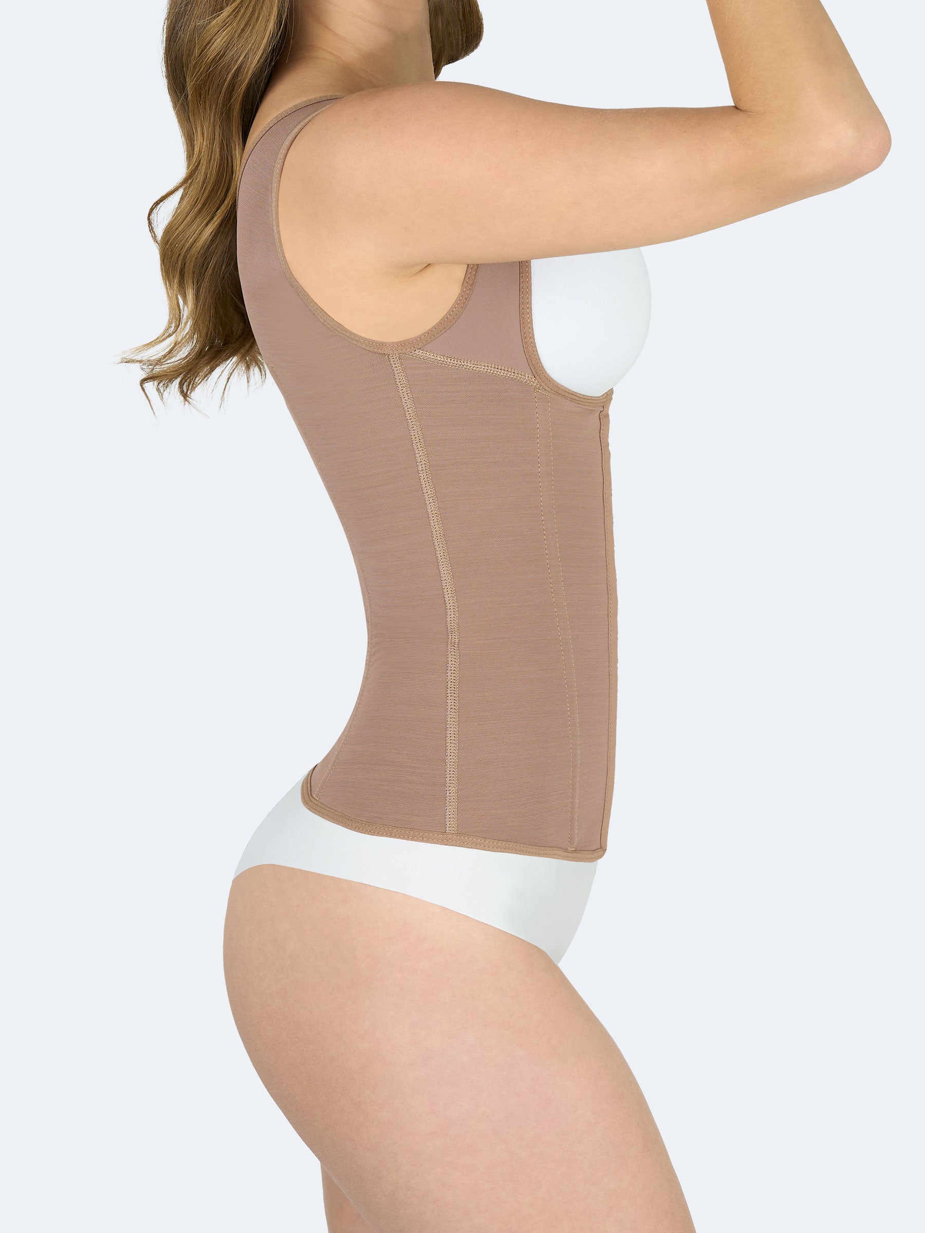 Mujer mostrando Chaleco Moldeador en color moca, Faja Colombiana vista lateral que estiliza la cintura, ofrece control abdominal y soporte en la espalda #color_Mocha / Moca