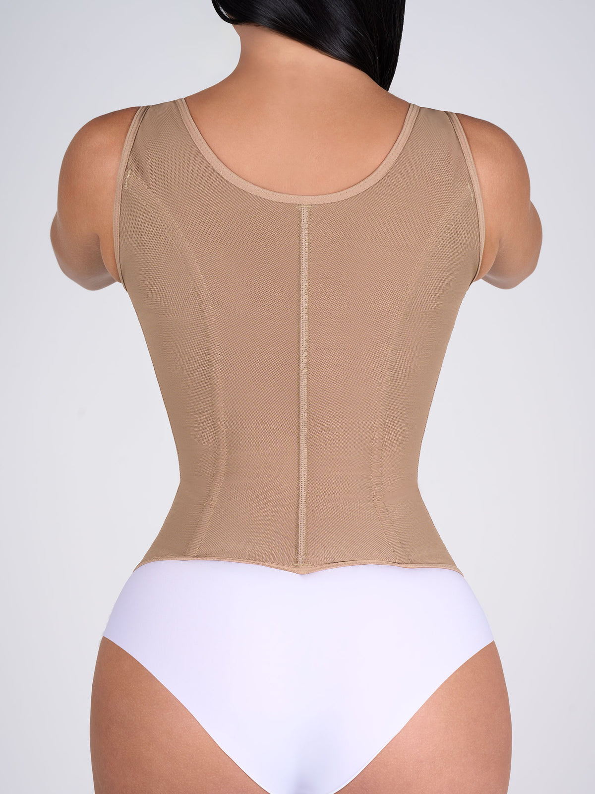 Woman showing the back of the mocha Shaping Vest, Colombian shapewear that offers back support and helps improve posture #color_Mocha