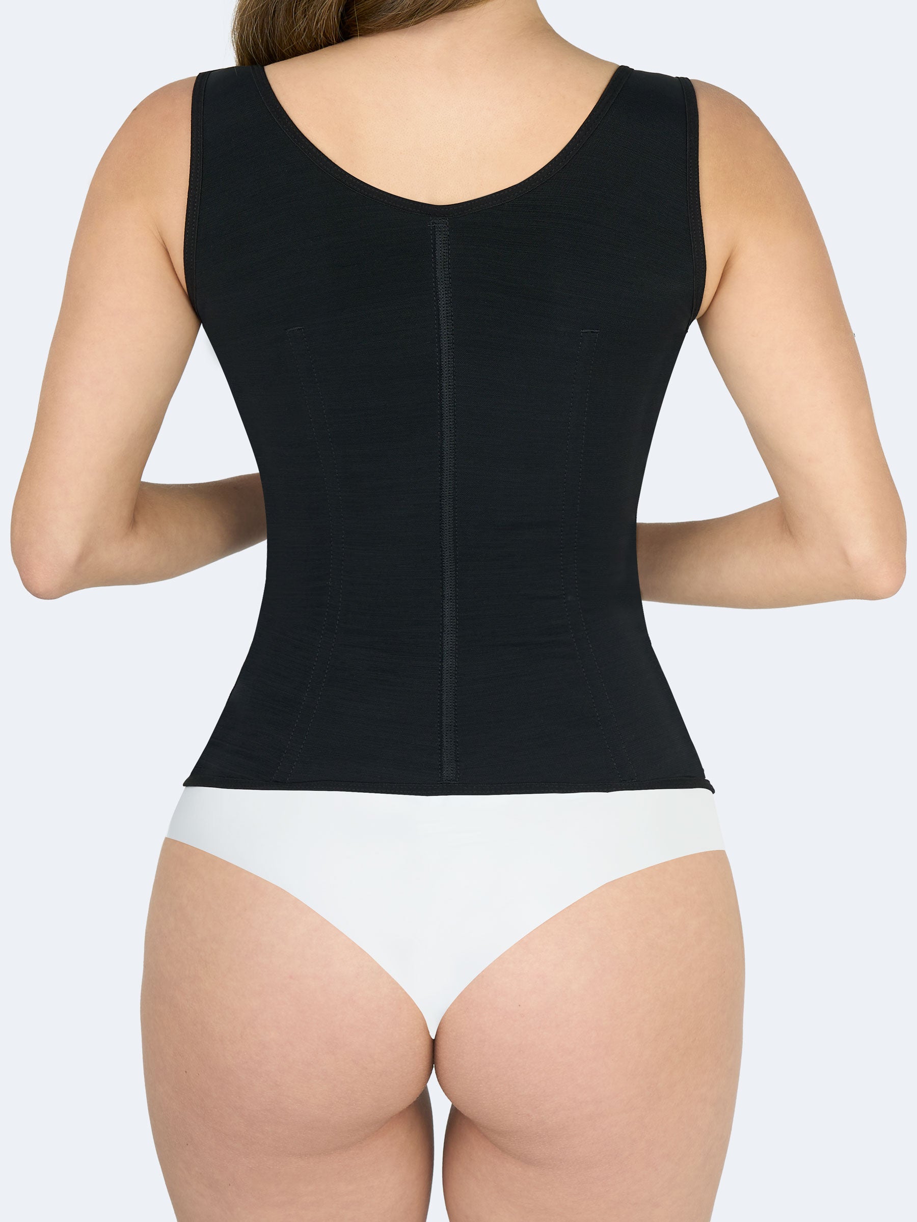 Mujer mostrando parte trasera del Chaleco Moldeador en color negro, Faja Colombiana que brinda soporte en la espalda y moldea la figura de forma natural #color_Black / Negro