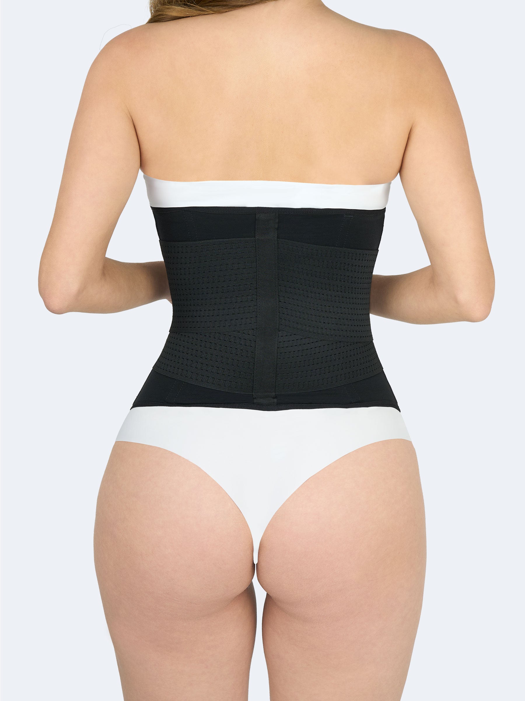 Mujer mostrando la parte trasera de la Cinturilla Reloj de Arena con Elásticos en color negro, Faja Colombiana que define cintura y proporciona soporte lumbar #color_Black / Negro