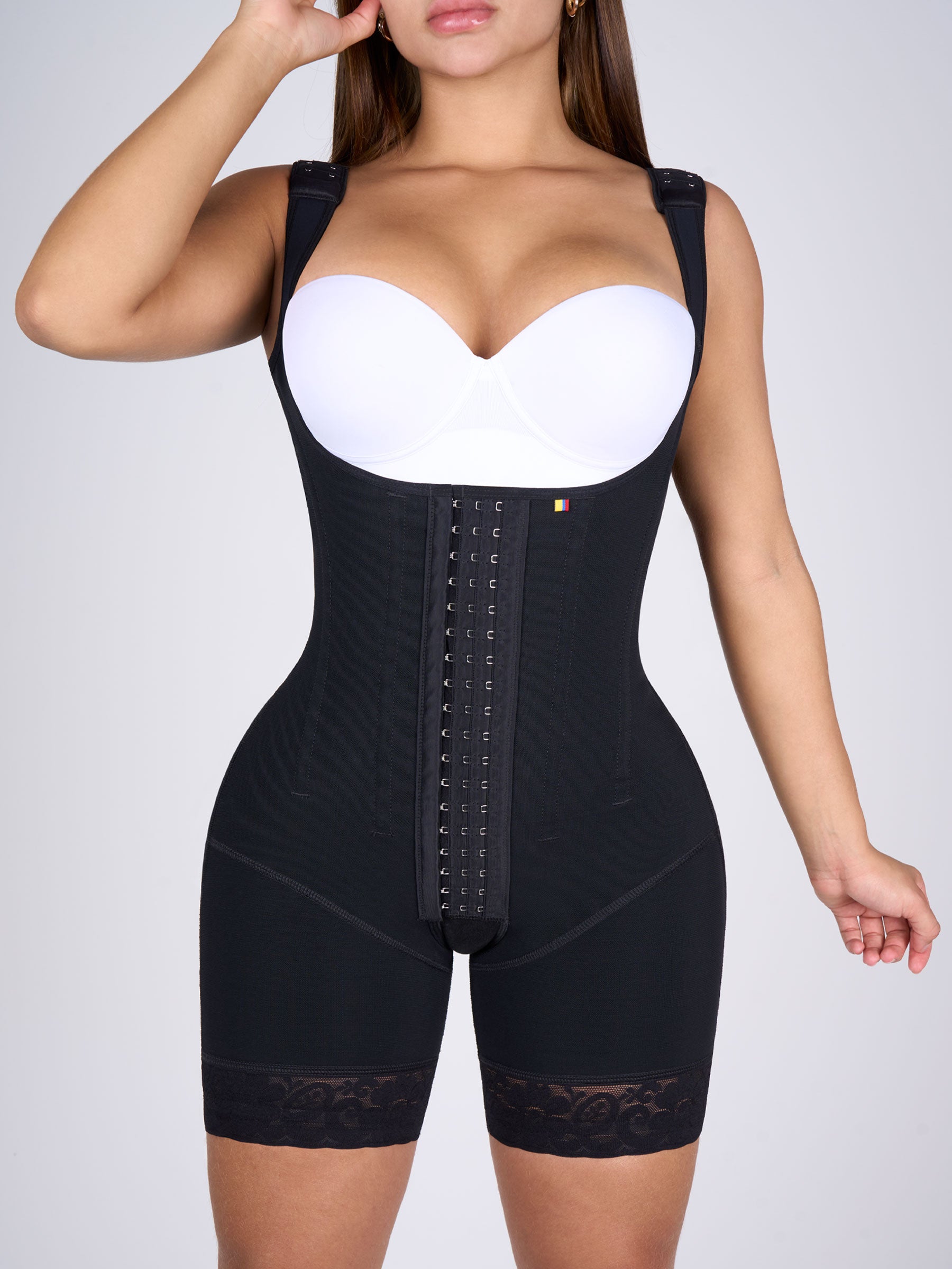 Mujer usando faja colombiana full body negra con broches y varillas, que moldea cintura, abdomen y muslos logrando un efecto reloj de arena #color_Black / Negro