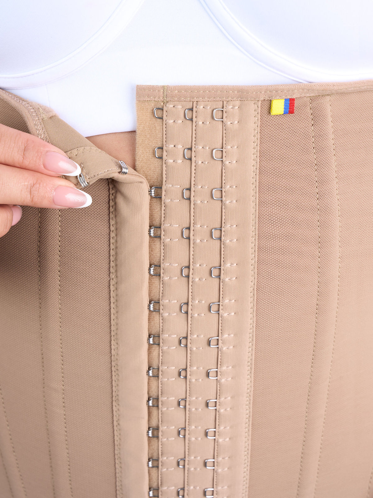 Detail of the front hook closure with 3 levels of adjustment on the mocha waist cincher, Colombian shapewear that lets you adjust the compression to define the waist #color_Mocha