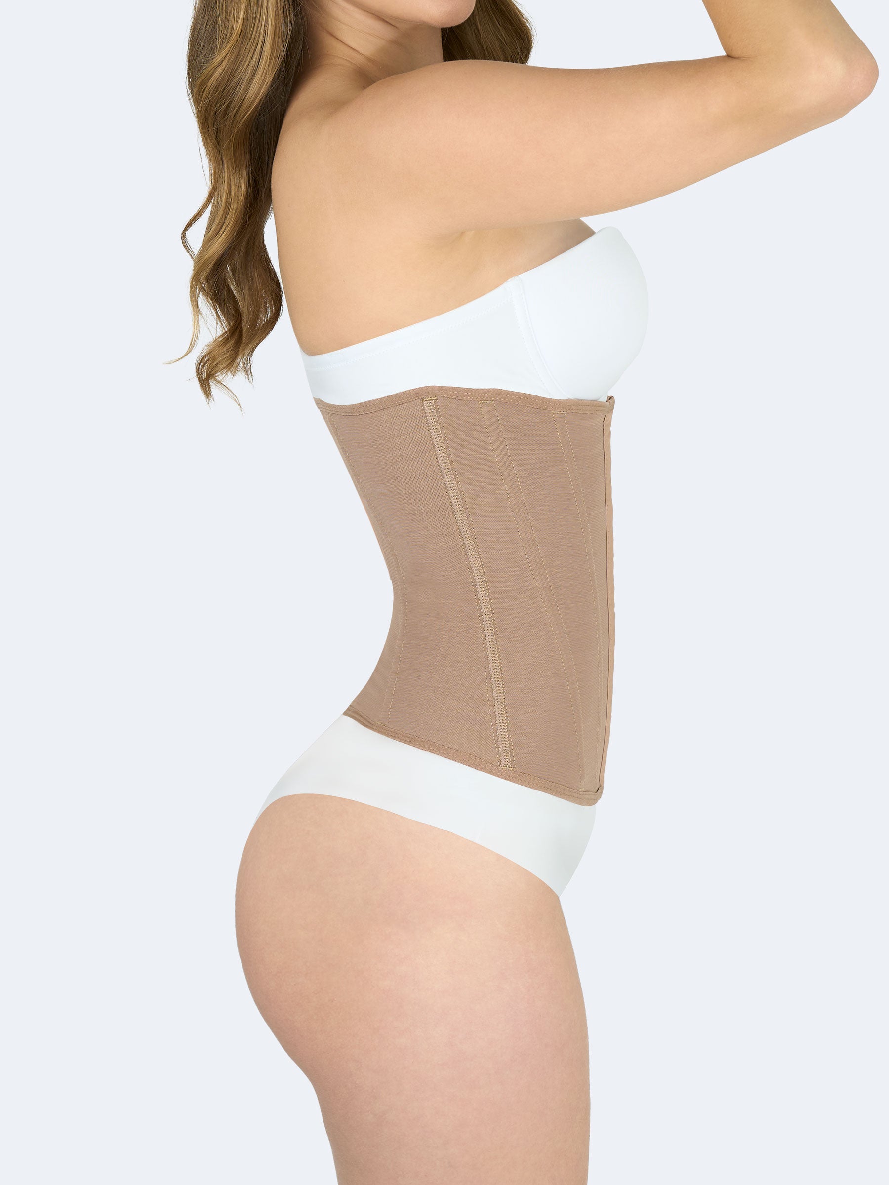 Mujer mostrando cinturilla moldeadora en color moca, Faja Colombiana vista lateral que estiliza la cintura y ofrece control abdominal #color_Mocha / Moca