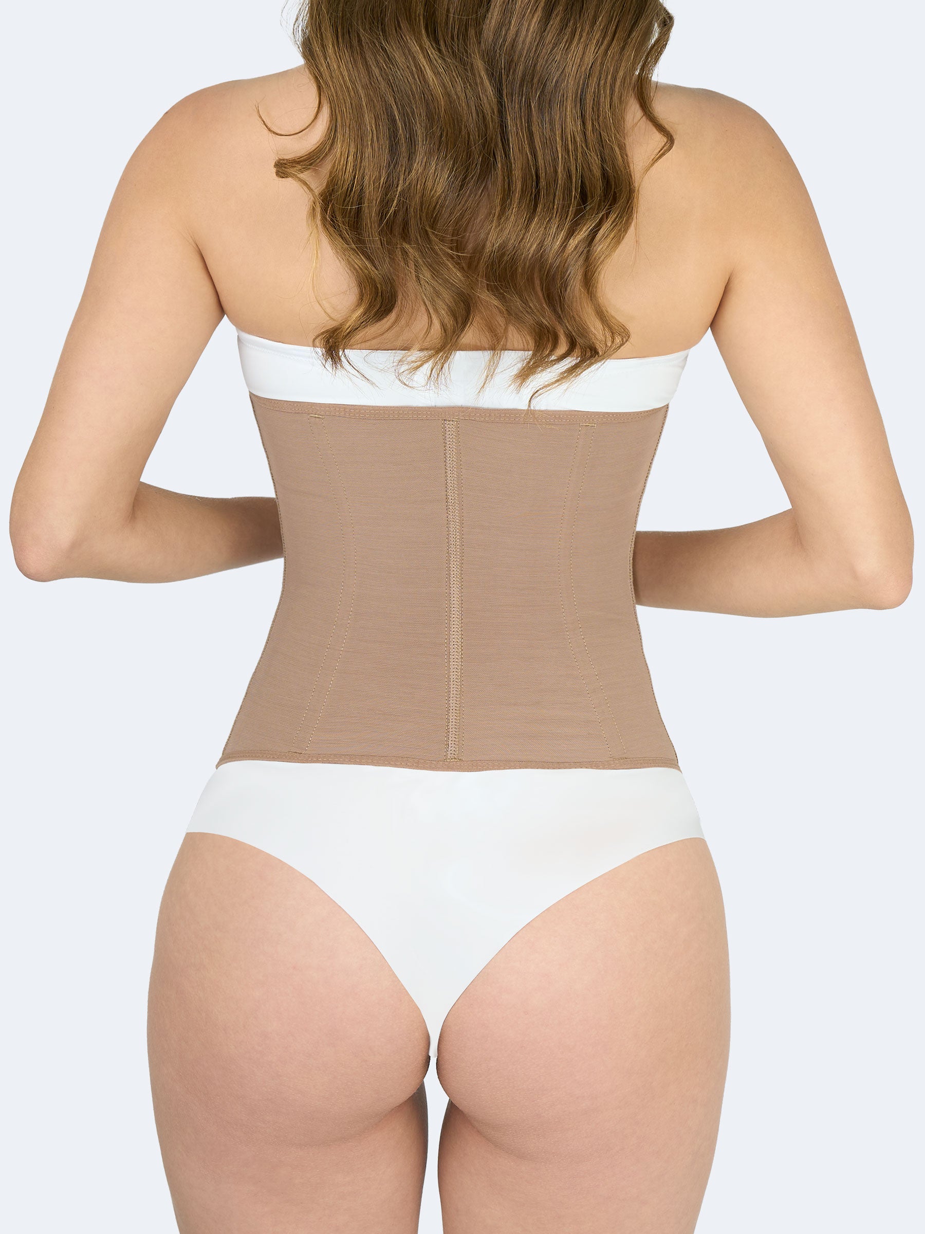 Mujer mostrando la parte trasera de una cinturilla moldeadora en color moca, Faja Colombiana que define cintura y brinda soporte lumbar #color_Mocha / Moca