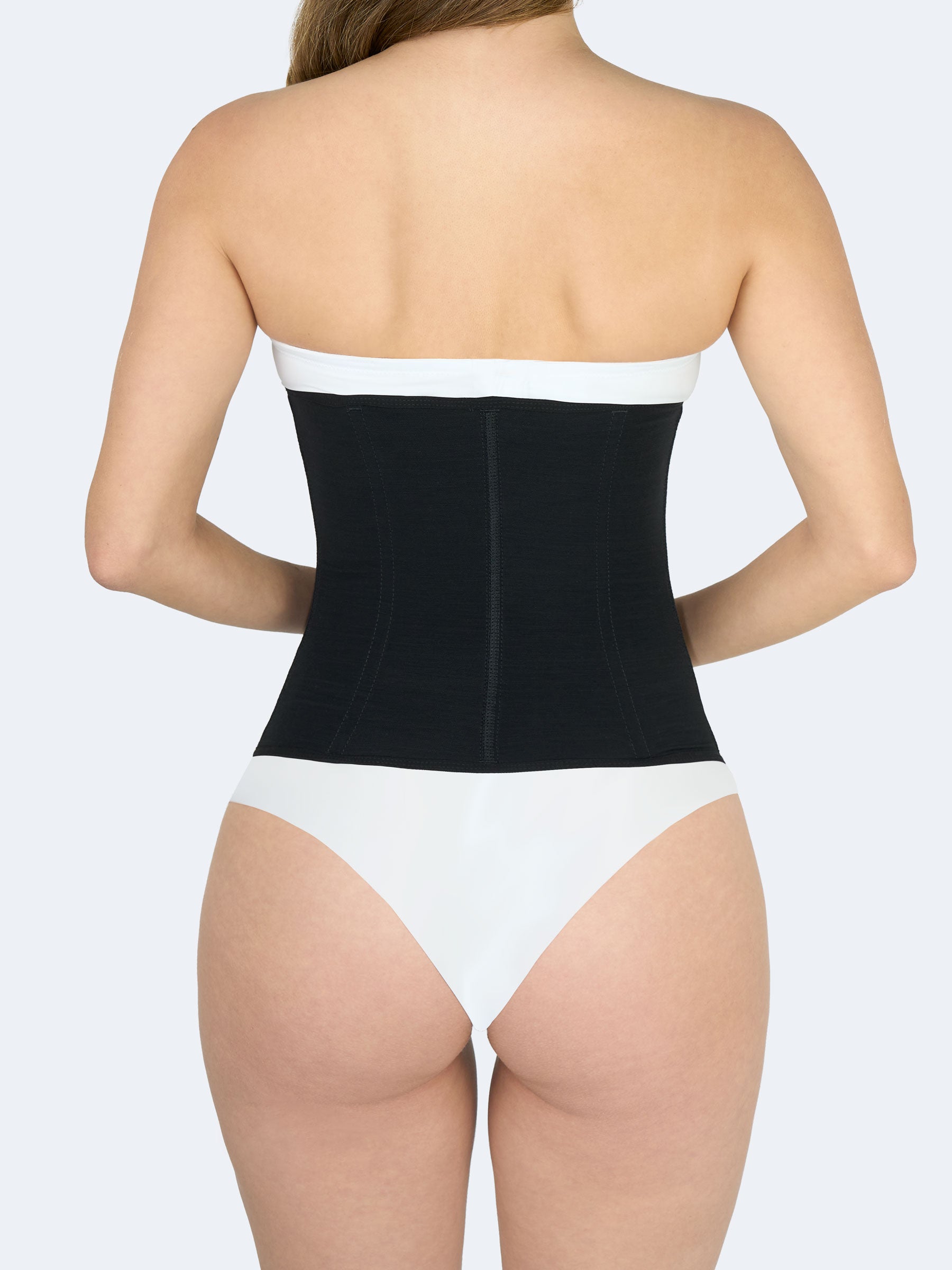 Mujer mostrando la parte trasera de una cinturilla moldeadora en color negro, Faja Colombiana que define cintura y brinda soporte lumbar #color_Black / Negro