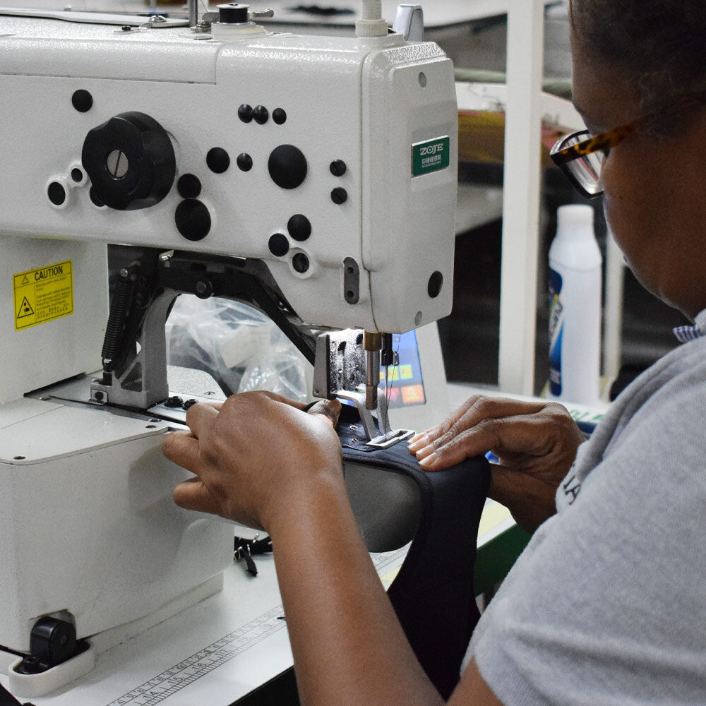 Mujer cociendo fajas colombianas en máquina de coser dentro de una planta de producción en Colombia.