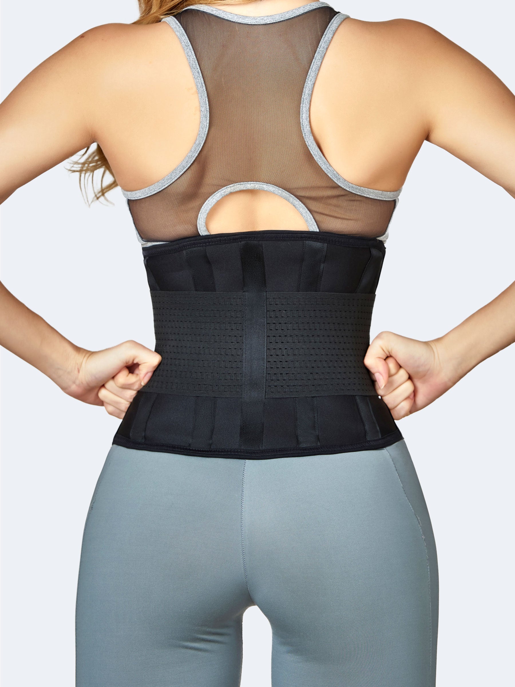Mujer de espaldas usando cinturón en elástico negro, faja colombiana deportiva con varillas y ajuste de compresión en la cintura#color_Black / Negro