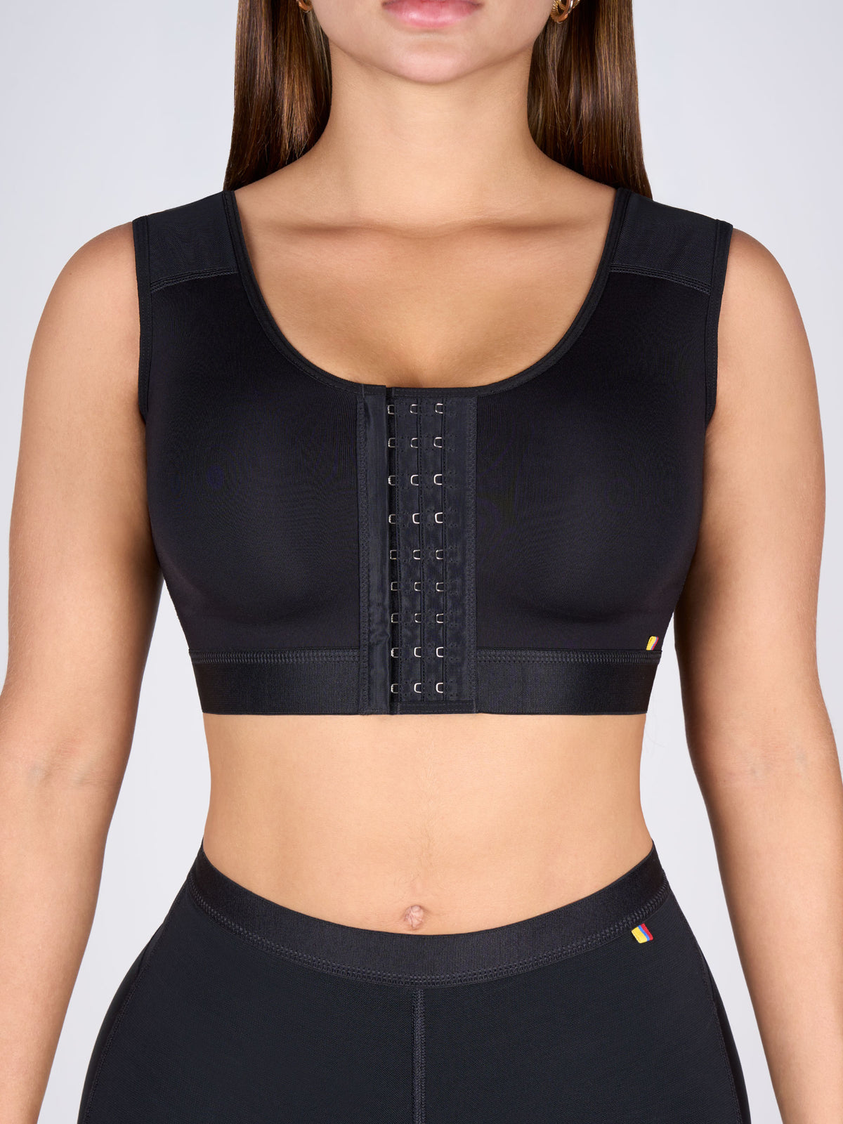 Mujer usando brasier para busto pesado color negro con broches frontales de varias filas que brindan soporte firme y ajuste seguro #color_negro