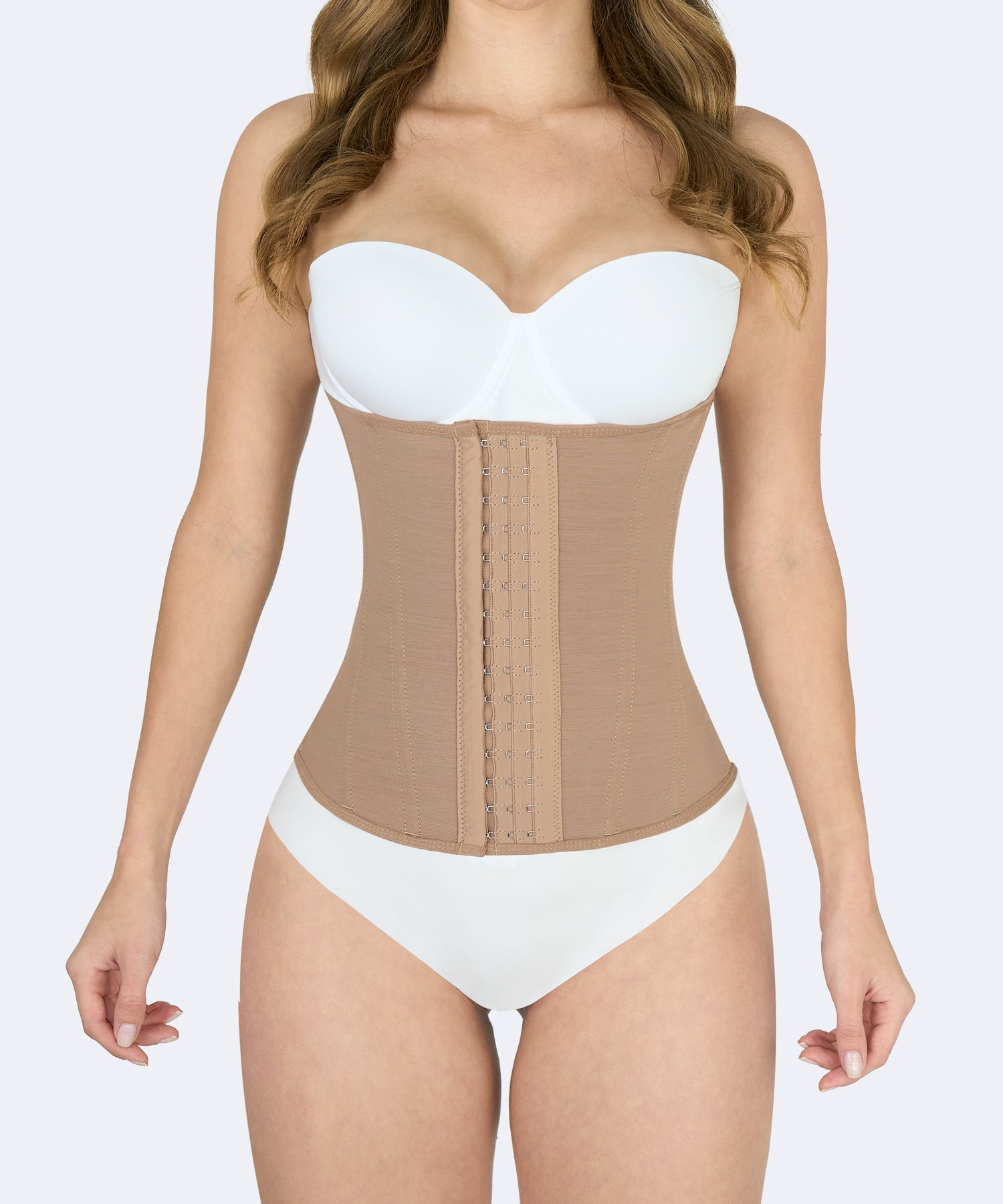 Mujer usando faja colombiana cinturilla color moca con broches frontales para moldear cintura y reducir medidas