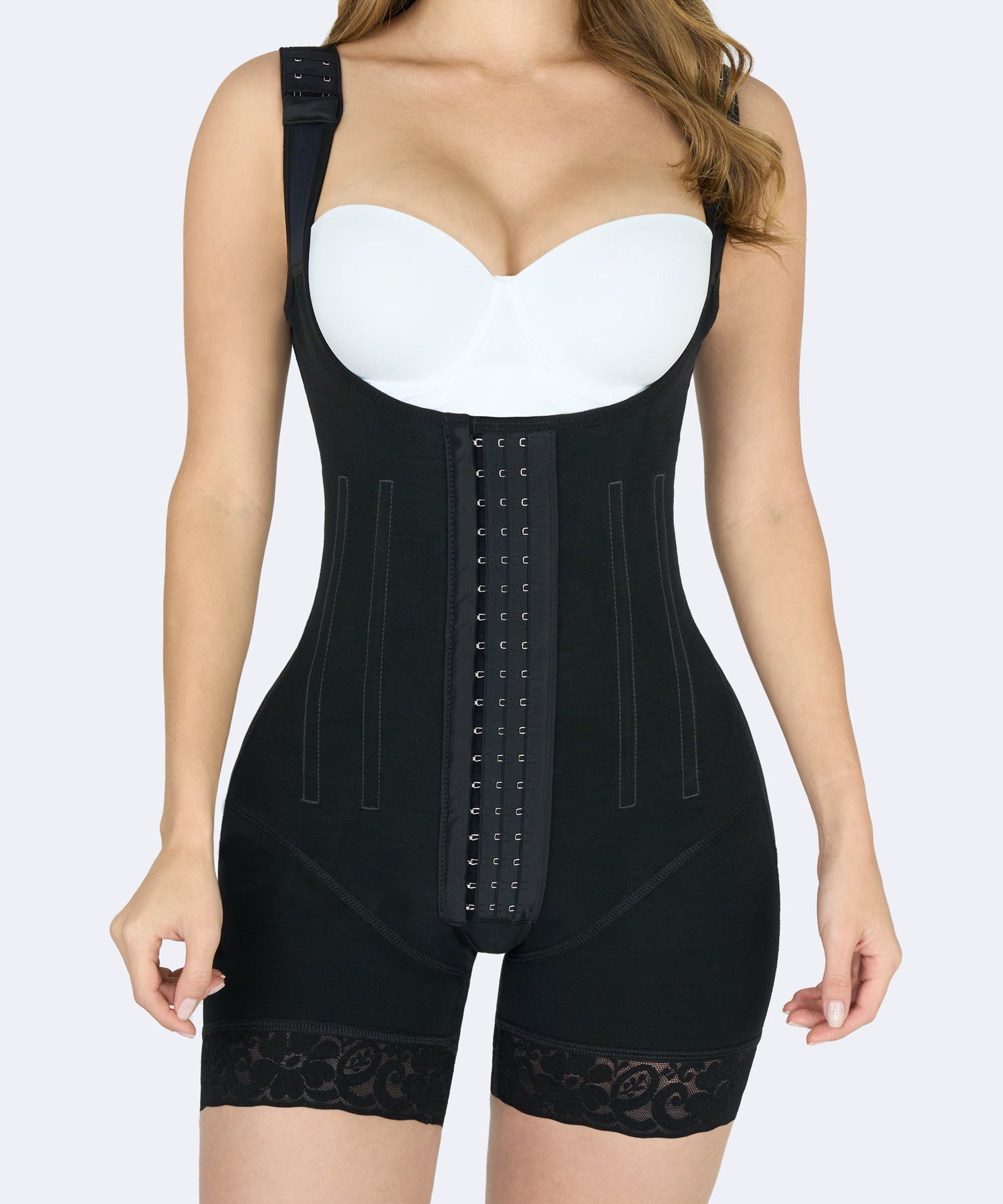 Mujer usando faja colombiana full body negra de alta compresión con broches frontales, ideal para moldear abdomen, cintura y muslos