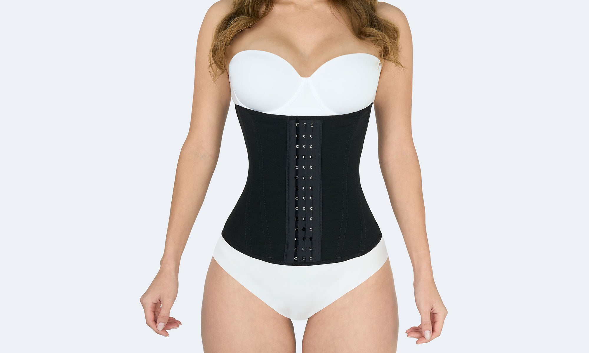 Mujer usando faja colombiana cinturilla color negro con broches frontales para moldear cintura y reducir medidas