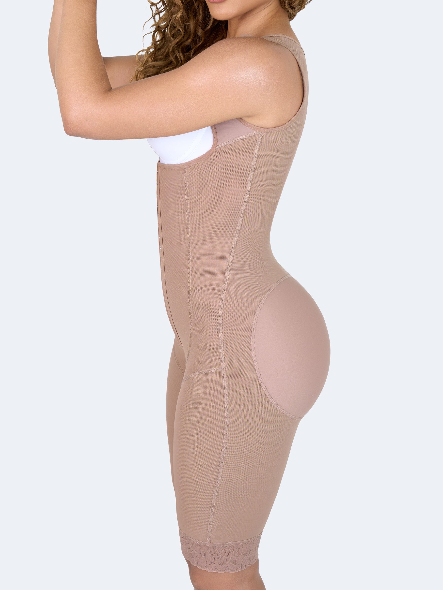 Mujer usando faja colombiana full body larga color moca con broches, vista lateral cuartos que moldea cintura, abdomen y caderas, brindando compresión y ajuste cómodo #color_Mocha / Moca