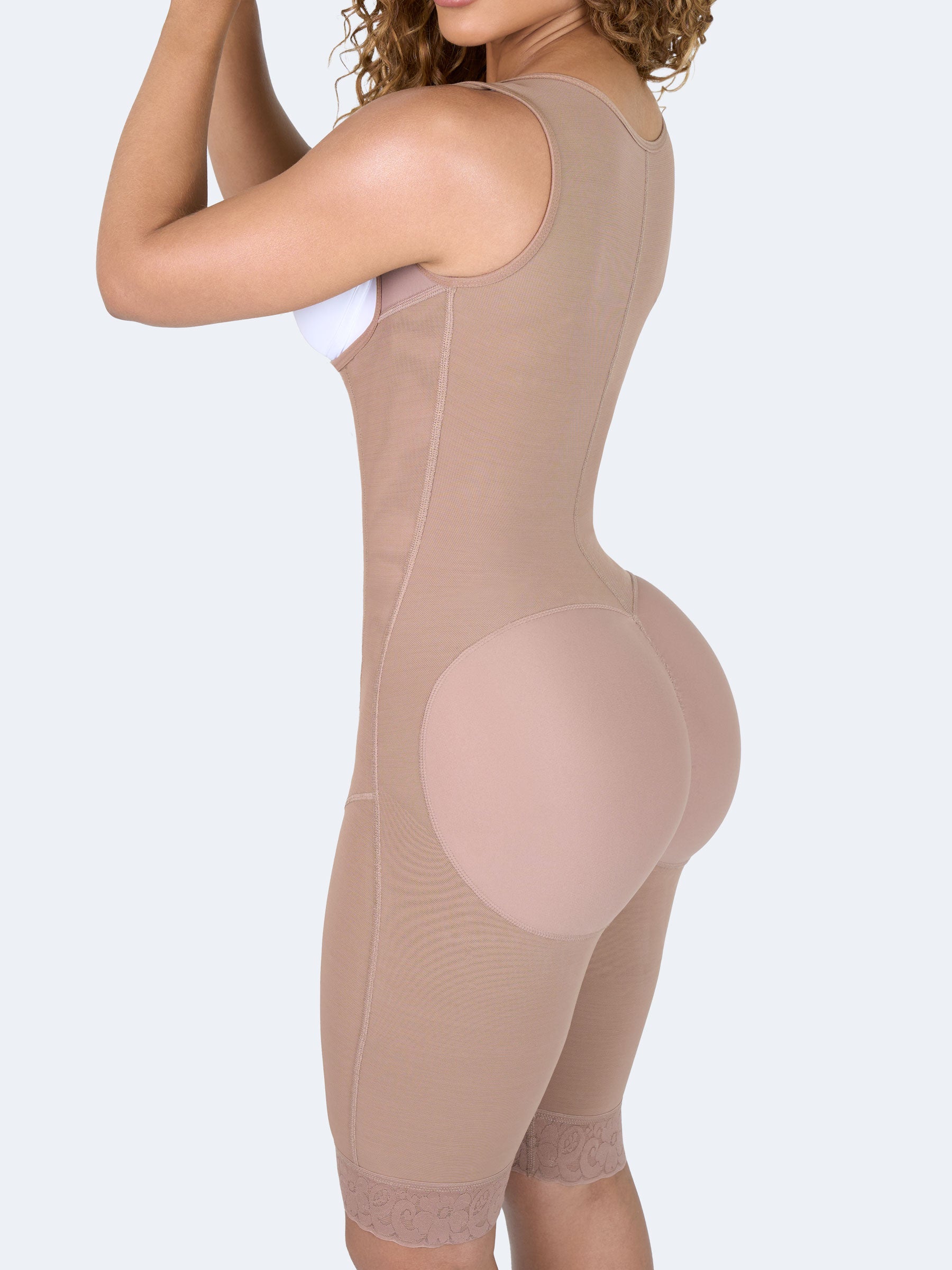 Mujer usando faja colombiana full body larga color moca con broches, vista tres cuartos que moldea cintura, abdomen y caderas, brindando compresión y ajuste cómodo #color_Mocha / Moca