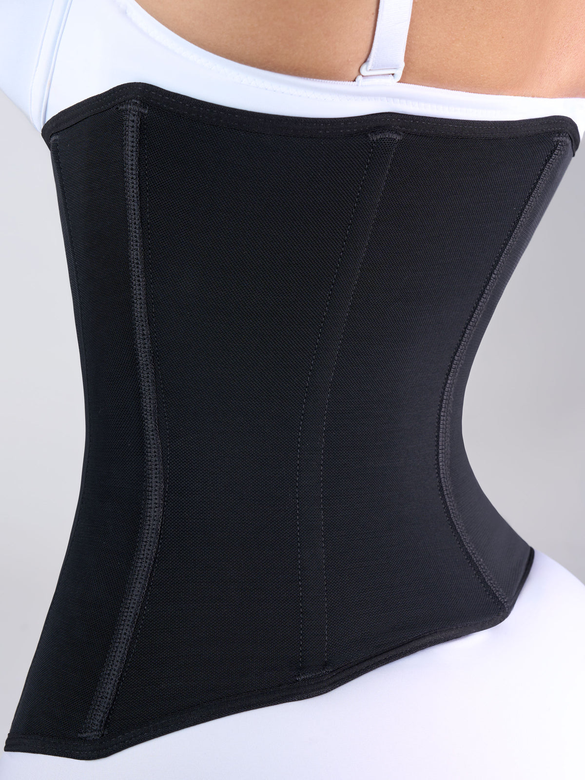 Back detail of the black waist cincher with coverage over the lower back, Colombian shapewear that accentuates the curve of the waist and slims the back #color_Black