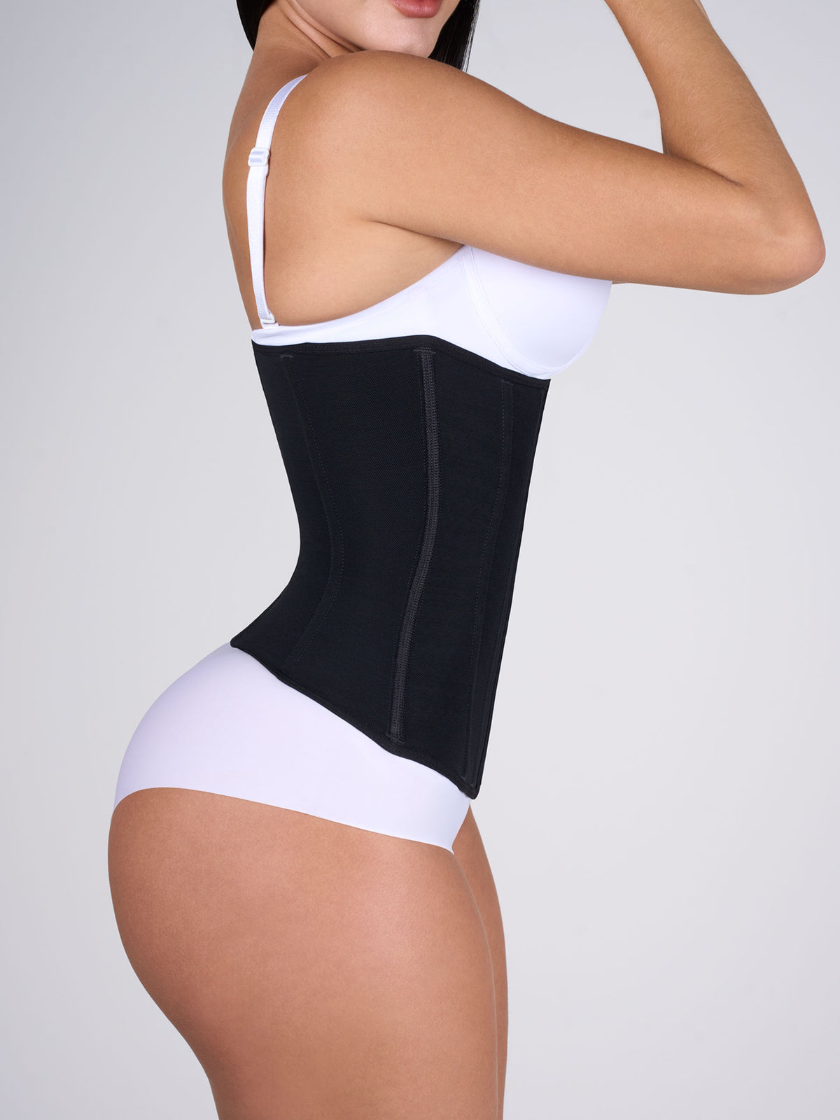 Woman showing the black Waist Cincher from the side, Colombian shapewear that slims the waist and offers tummy control #color_Black