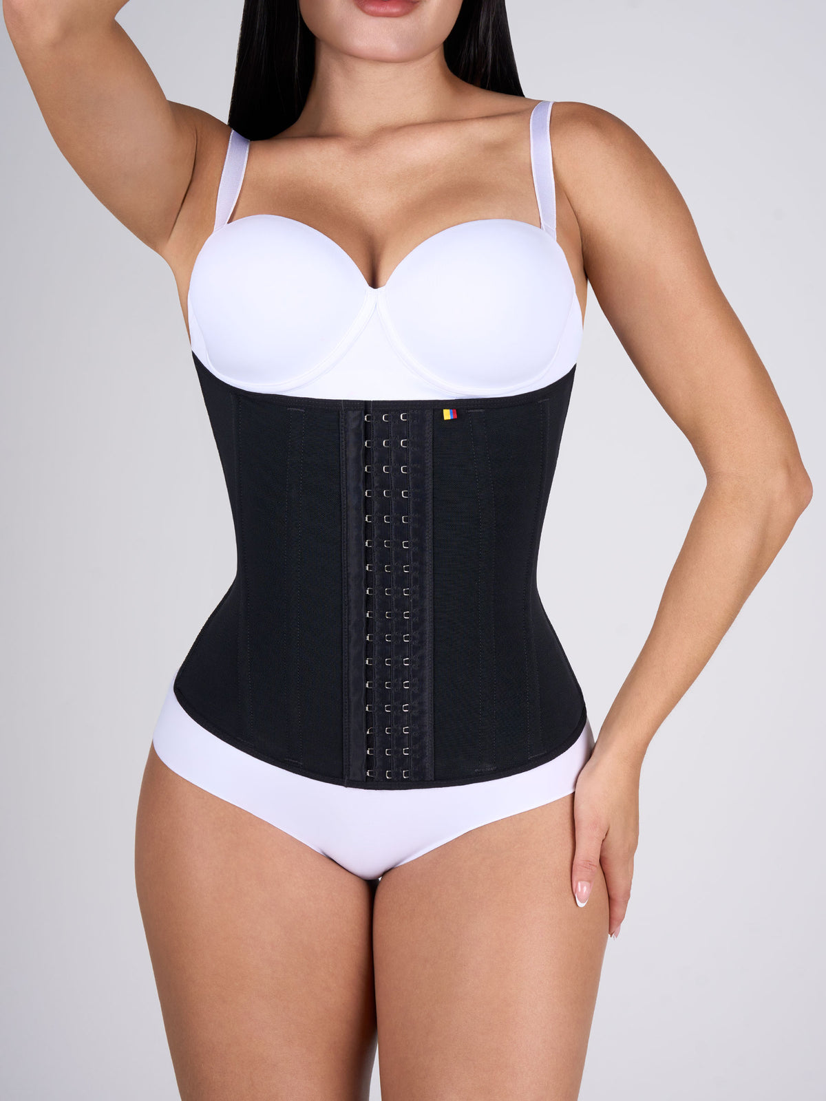 Woman wearing the black Waist Cincher, front-hook Colombian shapewear that defines the waist and slims the figure #color_Black