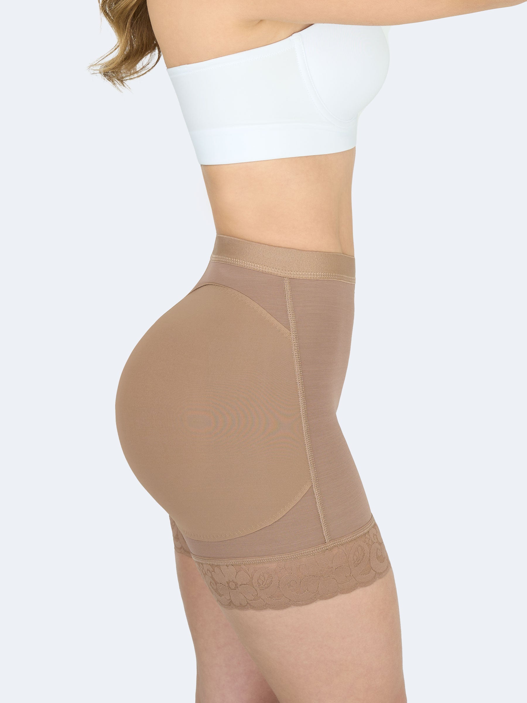 Mujer usando short levanta cola corto en color cocoa, Faja Colombiana que moldea la cintura y realza los glúteos con encaje floral en los muslos. #color_Mocha / Moca