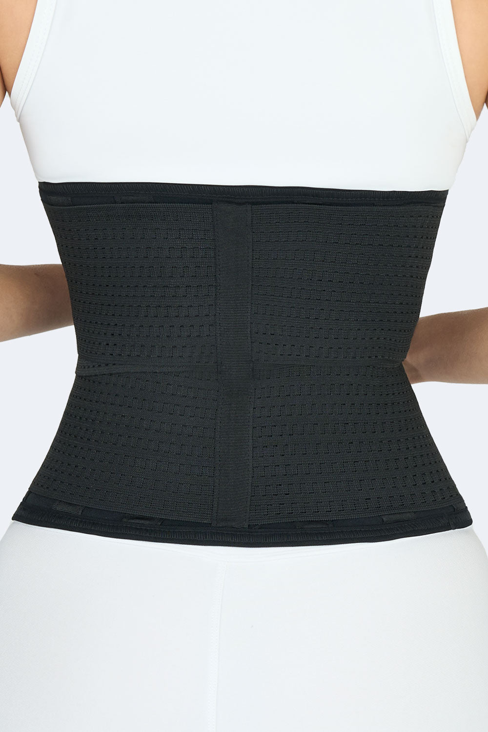 Vista posterior detalle de faja colombiana deportiva, cinturon doble en neopreno negro con diseño ajustable y elásticos de compresión