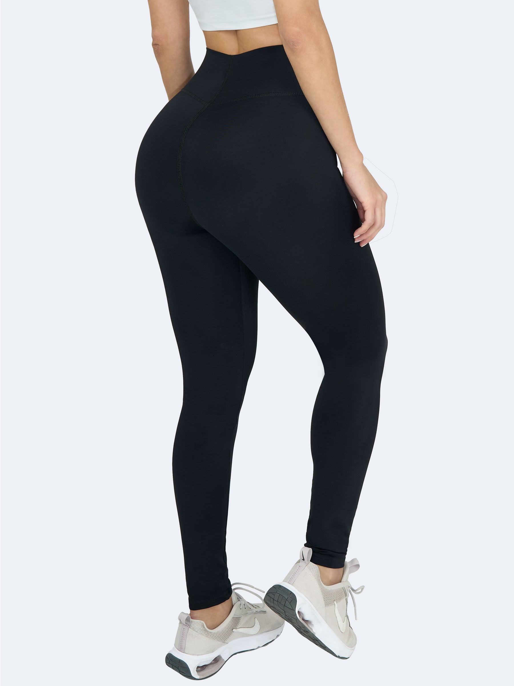 Mujer usando leggings negros levanta cola de talle alto, hechos en Colombia, que realzan glúteos y estilizan la figura para deporte o uso diario #color_Black / Negro